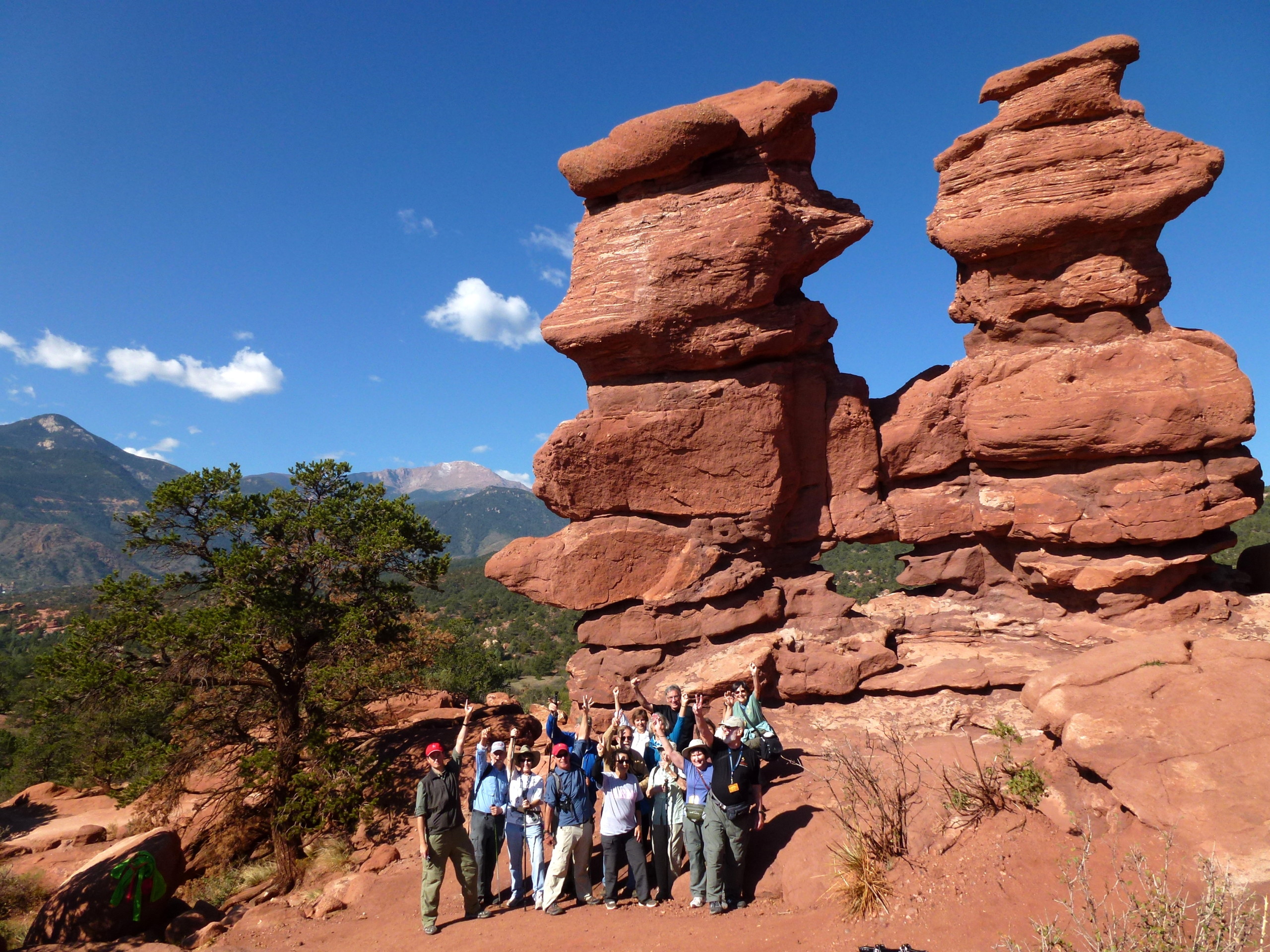 hikers by a red rock formation